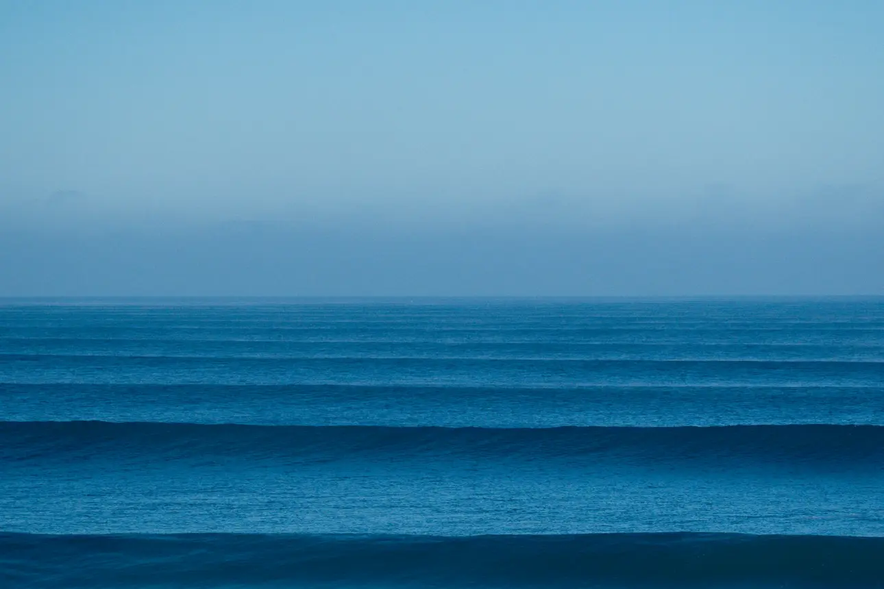 a large body of water sitting under a blue sky